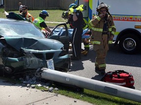 Windsor firefighters and Essex-Windsor EMS paramedics attended the scene of a single-vehicle collision where a Pontiac Grand Am lost control and crashed into an utility pole in the 11800 block of Little River Road in Windsor, Ont., May 15, 2013. The driver of the car was placed on a backboard and taken to hospital. (NICK BRANCACCIO/The Windsor Star)