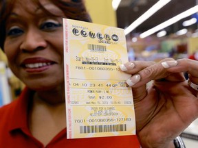 Dean Davis displays the Powerball ticket she bought at a Baker's supermarket in Omaha, Neb., Wednesday, May 15, 2013. (AP Photo/Nati Harnik)