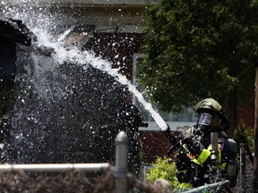 Firefighters work to extinguish any remaining hot spots after a fire destroyed a garage in the 1100 block of Hall Avenue in Windsor on Friday, May 24, 2013. (TYLER BROWNBRIDGE/The Windsor Star)