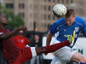 Detroit City FC's Cyrus Saydee, left, is beaten to the ball by AFC Cleveland's Shane Powell during the Detroit City FC home opener against the visiting AFC Cleveland at Cass Technological High School in downtown Detroit, Friday, May 17, 2013. Detroit won 2-1.  (DAX MELMER/The Windsor Star)