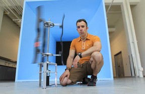 Rupp Carriveau, associate professor at the University of Windsor's Centre for Engineering Innovation, stands with a Starling Vertical Axis Wind Turbine near the Open Loop Wind Tunnel on May 13, 2013.  Carriveau recently gave a talk on what he sees for the near future. He says he thinks people will produce their own energy, or buy it locally from local sources or even a neighbour. (JASON KRYK/The Windsor Star)