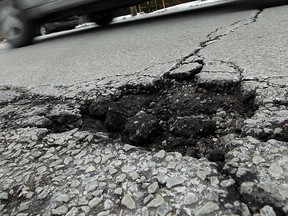 File photo of a car streaming past a pothole on the streets of Windsor.  (Windsor Star files)