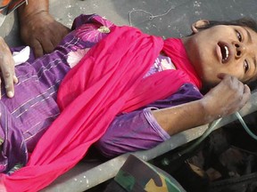 Bangladeshi rescuers retrieve garment worker Reshma from the rubble of a collapsed building in Savar on May 10, 2013, seventeen days after the eight-storey building collapsed. The death toll from last month's collapse of a garment factory complex in Bangladesh rose past 1,000 as piles of bodies were found in the ruins of a stairwell where victims had sought shelter. AFP PHOTO/STRSTRDEL/AFP/Getty Images