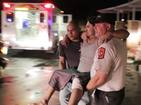 Johnny Ortiz, left, and James South, right, carry Miguel Morales, center, who was injured in a tornado, to an ambulance in Granbury, Texas, on Wednesday May 15, 2013. Officials report the tornado caused "multiple fatalities" as it tore through two neighborhoods of a North Texas town. Hood County sheriff's Lt. Kathy Jiveden reported the multiple fatalities, but she had no estimate of dead or injured. (AP Photo/Mike Fuentes)