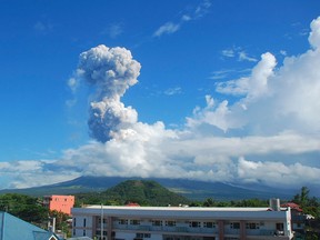 A cloud of volcanic ash shoots up to the sky as Mayon volcano, one of the Philippines' most active volcanoes, erupts after daybreak, viewed from Legazpi city Tuesday, May 7, 2013. At least five climbers were killed and more than a dozen others are trapped near the crater in its first eruption in three years, officials said. Rescue teams and helicopters were sent to Mayon volcano in the central Philippines to bring out the dead. (AP Photo/Allan Imperial)