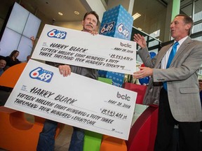 Harry Black, left collects his 6/49 Lottery winnings from Kevin Gass, vice-president of Lottery Gaming at BCLC, right, at the BCLC offices in Vancouver Tuesday, May 28, 2013. Black held two of the four winning tickets for the April 13, 2013, draw and won half of the $63-million jackpot.
(Photograph by: Ric Ernst , PNG)