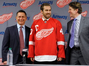 Red Wings general manager Ken Holland, left, and head coach Mike Babcock, right, stand with new captain Henrik Zetterberg.  (AP Photo/Detroit News, David Guralnick)