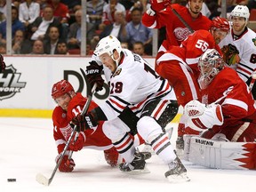 Chicago's Jonathan Toews, centre, is checked by Detroit's Daniel Cleary in front of Jimmy Howard in Game 3 of the Western Conference semifinal. (Photo by Gregory Shamus/Getty Images)