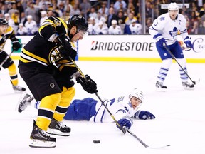 Boston's Brad Marchand, centre, is checked by Toronto's Carl Gunnarsson at TD Garden in Boston. (Photo by Jared Wickerham/Getty Images)