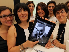 Martinos family members Kinsey Mantay, left, Paula Mantay, Ramza Saruna, Carol Lee Martinos, right, along with Troy Saruna, Zak Saruna and Mike Saruna, behind right, hold an iPad and an image of the late Martin Martinos during the announcement of The Martin Martinos Memorial Communications Program through the generous financial support of Transition to Betterness at The Hospice of Windsor and Essex County Inc. Thursday May 30, 2013.  (NICK BRANCACCIO/The Windsor Star)