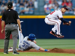 Atlanta's Andrelton Simmons, right, turns a double play over Colby Rasmus of the Toronto Blue Jays in the third inning at Turner Field in Atlanta. (Photo by Kevin C. Cox/Getty Images)