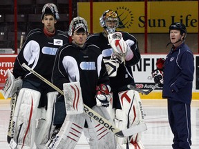 Spitfires goaltenders Jordan DeKort, from left, Dalen Kuchmey and Jaroslav Pavelka gather with coach Paul Billing at the WFCU Centre last year. (NICK BRANCACCIO/The Windsor Star)