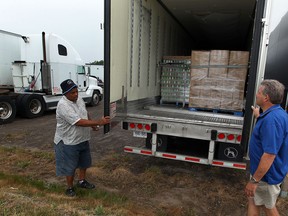 Pastor Howard Mulder, left, and Dennis Sauve check a huge, tractor-trailer load of donated goods destined for Oklahoma MAY 31, 2013.  The goods remain in a Leamington trucking yard after being turned away at the border.  (NICK BRANCACCIO/The Windsor Star)