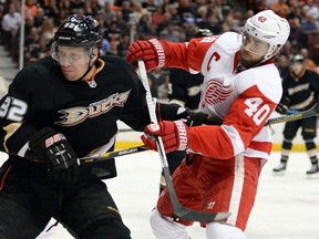 Detroit's Henrik Zetterberg, right, is checked by Anaheim's Toni Lydman. (Photo by Harry How/Getty Images)