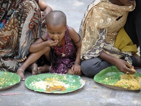 Indian homeless eat food at a feeding program for the poor in Hyderabad on March 17, 2013. India still has the worlds largest number of impoverished in a single country,  of its nearly one billion inhabitants, an estimated 350-400 million live below the poverty line with 75 percent of them in the rural areas.  (Noah SEELAM/AFP/Getty Images)