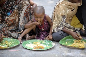 Indian homeless eat food at a feeding program for the poor in Hyderabad on March 17, 2013. India still has the worlds largest number of impoverished in a single country,  of its nearly one billion inhabitants, an estimated 350-400 million live below the poverty line with 75 percent of them in the rural areas.  (Noah SEELAM/AFP/Getty Images)