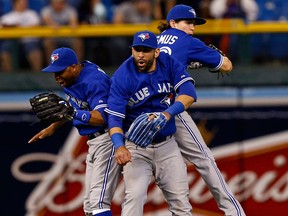 Toronto's Rajai Davis, from left, Jose Bautista and Colby Rasmus celebrate a win over the Tampa Bay Rays Monday. (AP Photo/Mike Carlson)