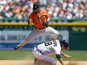 Astros second baseman Jake Elmore jumps over Detroit's Matt Tuiasosopo after Tigers batter Brayan Pena grounded into a double play during the fourth inning of a baseball game in Detroit Wednesday, May 15, 2013. (AP Photo/Carlos Osorio)
