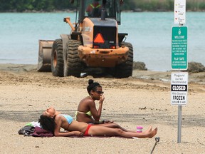 Jessica Ennis (L) and Ashley Baylis catch some rays at Sandpoint Beach while city workers prepare the area for the summer season. Photographed May 31, 2013. The beach officially begins its supervised hours on June 1. (Tyler Brownbridge / The Windsor Star)