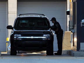 A CBSA officer checks a vehicle and its occupants at the Detroit-Windsor tunnel in this October 2012 file photo.