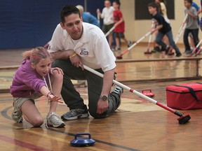 Students at the Belle River Public School were learning the sport of curling, Tuesday, April 30, 2013, at the Belle River, Ont. school. Simon Barrick, a curling instructor works with Sara Mills. (DAN JANISSE/The Windsor Star)