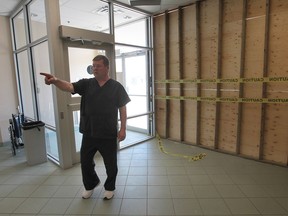 Chris Fader, a nurse at the Hotel-Dieu Grace HospitalÕs satellite dialysis unit on Dougall Ave. surveys the boarded windows in the lobby, Friday, May 3, 2013, in Windsor, Ont. An allegeded drunk driver crashed through the wall Thursday evening. (DAN JANISSE/The Windsor Star)