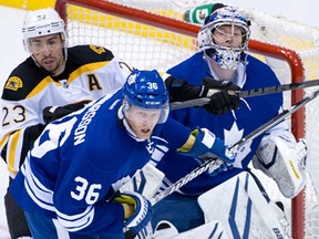 Toronto's Carl Gunnarsson, centre, and Boston Bruins' Chris Kelly, left, fight for position in front of Leafs goaltender James Reimer during Game 6 of the NHL Eastern quarter-final in Toronto Sunday, May 12, 2013.   (Darren Calabrese/National Post)