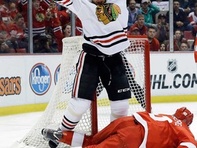 Chicago's Marian Hossa, top, celebrates his goal against the Detroit Red Wings during Game 6 of the Western Conference semifinal in Detroit, Monday, May 27, 2013. (AP Photo/Paul Sancya)