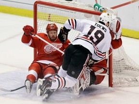 Chicago's Jonathan Toews, right, crashes into Detroit goalie Jimmy Howard and winger Johan Franzen, left, during Game 6 of the Western Conference semifinals in Detroit, Monday, May 27, 2013. (AP Photo/Carlos Osorio)