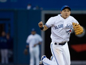 Blue Jays shortstop Munenori Kawasaki, right, forces out Boston Red Sox first baseman Mike Carp at second base during the fourth inning in Toronto on Thursday, May 2, 2013. THE CANADIAN PRESS/Nathan Denette