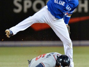 Toronto shortstop Maicer Izturis, top, forces out Atlanta's Freddie Freeman at second base then turns the double play during interleague action in Toronto Tuesday, May 28, 2013. (THE CANADIAN PRESS/Nathan Denette)