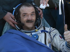 Canadian astronaut Chris Hadfield, gestures shortly after the landing of the Russian Soyuz TMA-07 space capsule about 150 km ( 90 miles) south-east of the Kazakh town of Dzhezkazgan, Tuesday, May 14, 2013.  A Soyuz space capsule with a three-man crew returning from a five-month mission to the International Space Station landed safely Tuesday on the steppes of Kazakhstan. (AP Photo/Mikhail Metzel, Pool)