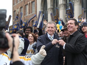 Nov. 30, 2012: Amid much fanfare, University of Windsor president Alan Wildeman, left, accepts the keys to the old Windsor Star building from editor-in-chief Marty Beneteau during a ceremony at Pitt and Ferry streets. (JASON KRYK / The Windsor Star)