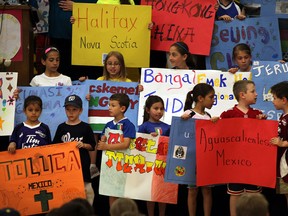 Notre Dame pupils hold placards on Friday with names of 84 cities from around the world, which will be sending athletes to the 2013 International Children's Games. (NICK BRANCACCIO / The Windsor Star)