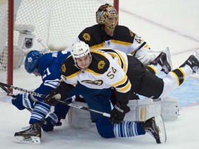 Toronto's James van Riemsdyk, left, collides with Boston's Adam McQuaid, front, as Bruins goalie Tuukka Rask, back, looks on during NHL hockey playoff action in Toronto Monday, May 6, 2013. (THE CANADIAN PRESS/Nathan Denette)