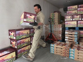 Harry Tofflemire, a driver for the food distribution charity Forgotten Harvest, unloads bell peppers at Century Secondary School on May 27, 2013. (Dan Janisse / The Windsor Star)