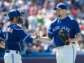 Toronto closer Steve Delabar, right, celebrates with catcher J.P. Arencibia after the Blue Jays beat the Seattle Mariners 10-2 in Toronto Sunday, May 5, 2013. (THE CANADIAN PRESS/Nathan Denette)