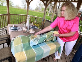 Rose Marie Roach  demonstrates an outdoor table setting at her home in Leamington.                  (TYLER BROWNBRIDGE / The Windsor Star)