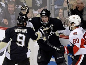 Pittsburgh's Sidney Crosby, centre, celebrates his second goal with teammate Pascal Dupuis, left, as Ottawa's Cory Conacher skates back to his bench during Game 2 of the Eastern Conference semifinal in Pittsburgh Friday, May 17, 2013.(AP Photo/Gene J. Puskar)