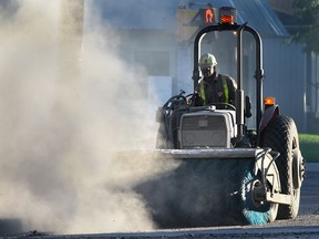 Files: Heavy machinery from Coco Paving kicks up some dust Oct. 4, 2011, in Windsor as a road was being repaved.(DAN JANISSE/The Windsor Star)