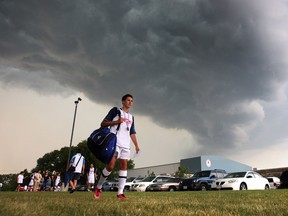 Holy Names Knights soccer player Noah Pio leaves the soccer field at Mic Mac park  as an approaching thunderstorm paints the sky on Thursday May 30, 2013 in Windsor, Ontario.   Holy Names defeated Chatham Ursuline College 3-0 to win the SWOSSAA boys soccer championship.  (JASON KRYK/The Windsor Star)