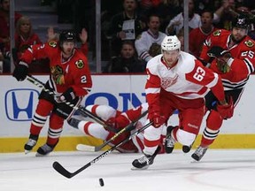 Detroit's Joakim Anderson, centre, chases the puck in front of Chicago's Viktor Stalberg, right, and Duncan Keith in Game 7 of the Western Conference Semifinals at the United Center on May 29, 2013 in Chicago, Illinois.  (Photo by Jonathan Daniel/Getty Images)
