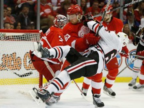 Detroit's Joakim Andersson, centre,  takes down Chicago's Andrew Shaw in front of the Wings' net during Game 4 of the Western Conference semifinal at Joe Louis Arena May 23, 2013 in Detroit. (Gregory Shamus/Getty Images)