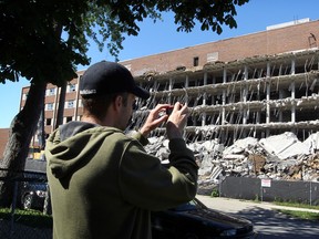 Dru LeHoux takes a video as demolition crews continue their work on ripping down the former Grace Hospital on Crawford Avenue at University Street, Monday May 3, 2013. (NICK BRANCACCIO/The Windsor Star)