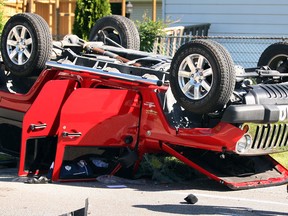 LaSalle Police Sgt. Mike Foreman, right, along with LaSalle firefighters and Essex-Windsor EMS paramedics at the scene of a two-vehicle collision at Maple and Michigan avenues where a 2012 Jeep Wrangler ended up on its roof Tuesday May 4, 2013.  The driver of the Jeep and another driver of a Dodge Grand Caravan were taken to hospital with non-lifethreatening injuries.  (NICK BRANCACCIO/The Windsor Star)