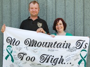 Jano Kascjak, 33, left, and Britt Kascjak, 27, hold an 'Exhibition of Hope' banner on Sunday, June 16, 2013, that they plan to display at the summit of Mount Kilimanjaro in September.  Britt Kascjak was diagnosed with ovarian cancer three years ago and has been cancer free for two years.  (DAX MELMER/The Windsor Star)