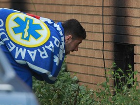 A young male, wrapped in an EMS blanket, looks through the basement window after he and another male escaped a house fire at 2175 Woodlawn Ave., Sunday, June 30, 2013.  (DAX MELMER/The Windsor Star)