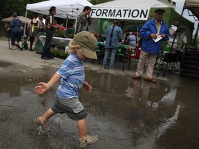 Elliott Stronk, 2, plays in a puddle at the Downtown Windsor Farmers' Market on its opening day at Charles Clark Square, Saturday, June 1, 2013.  (DAX MELMER/The Windsor Star)