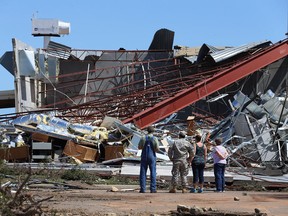 People survey the damage at the at Canadian Valley Technology Center's El Reno Campus after it was hit by a powerful tornado  on June 1, 2013 in El Reno, Oklahoma. The tornado ripped through the area killing at least nine people, injuring many others and destroying homes and buildings.  (Photo by Joe Raedle/Getty Images)
