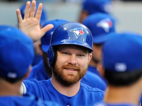 Toronto's Adam Lind celebrates in the dugout after scoring on a Maicer Izturis single during the second inning against the Chicago White Sox Tuesday. (AP Photo/Paul Beaty)